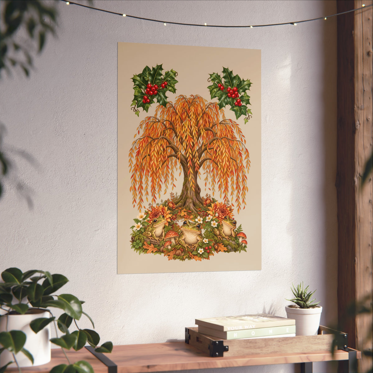 A vertical wall art print featuring an autumn tree with orange and gold leaves, red berries in holly branches, and small birds at the base, displayed on a white wall above a wooden console table with plants.