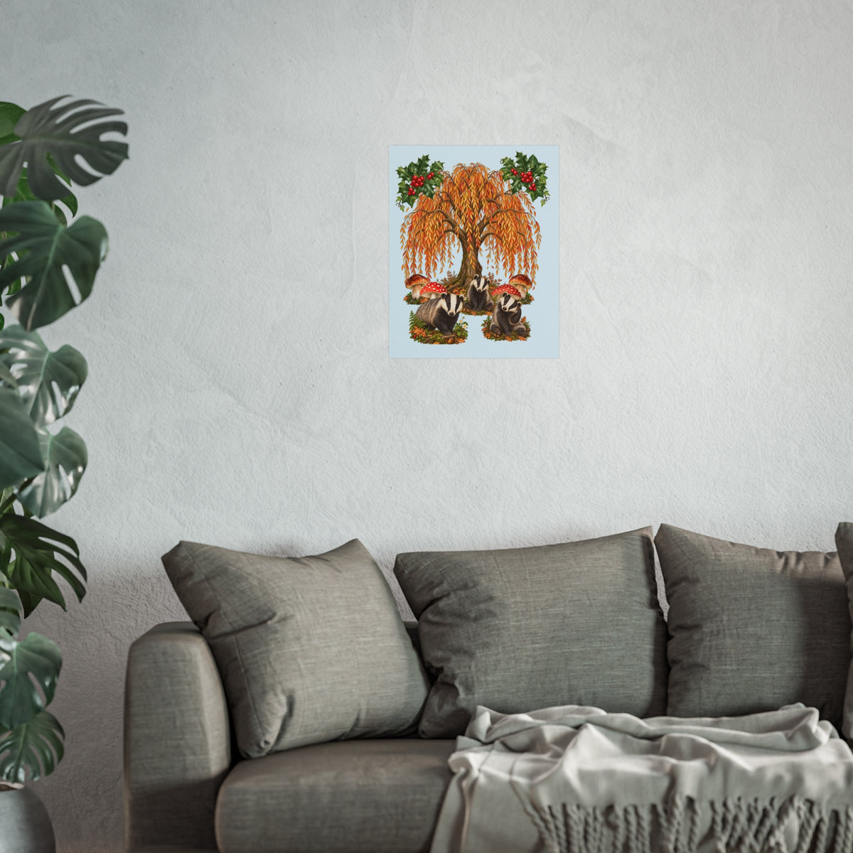 A square art print featuring a whimsical woodland scene with a large autumn tree, badgers, red-and-white mushrooms, and holly leaves on a pale blue background.