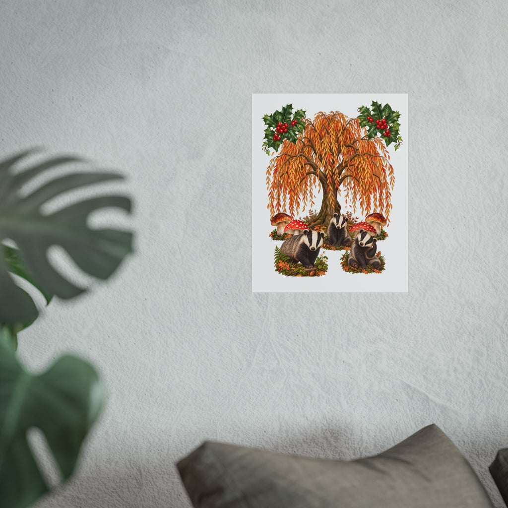 A vertical art print featuring a whimsical illustration of two badgers under a large orange autumn tree with mistletoe, displayed on a textured light gray wall with a blurred plant in the foreground.