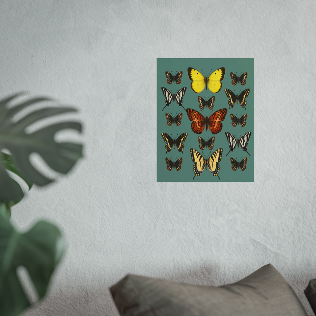 A square wall art print featuring a grid of illustrated butterflies on a muted teal background, displayed on a light textured wall above a sofa with a blurred plant in the foreground.